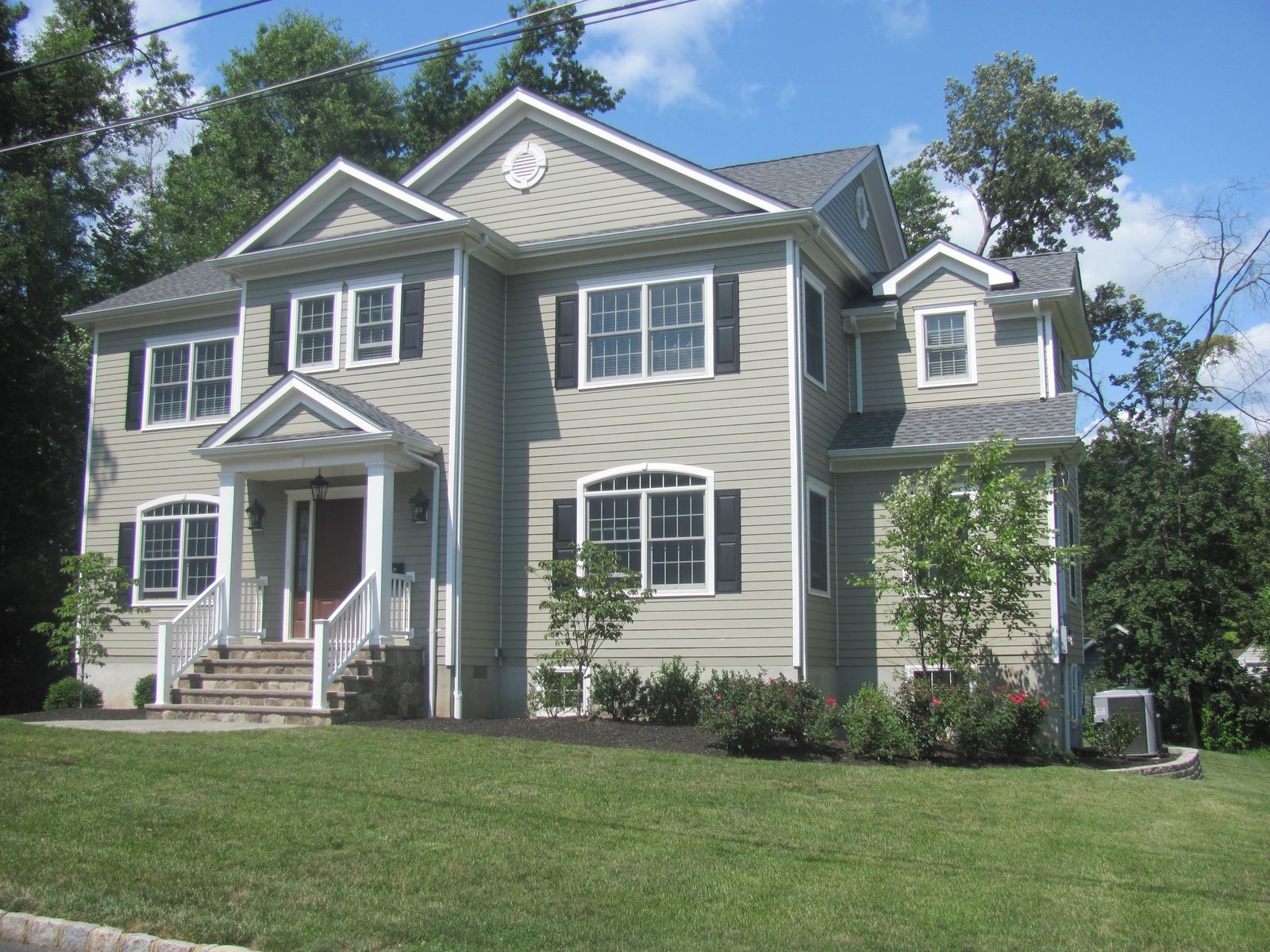 Two-story colonial new construction with a columned front entry